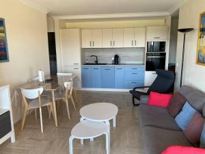 una sala de estar con un sofá y una mesa en Joli appartement calme avec vue piscine, en Mandelieu-la-Napoule