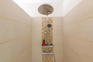 a shower with a shower head in a bathroom at Villa du Menhir 300m plage à pied in Plouescat +21 photos