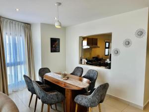 uma sala de jantar com uma mesa de madeira e cadeiras em Luxury home 75”TV, 5mins from City Center & Beach em Dar es Salaam