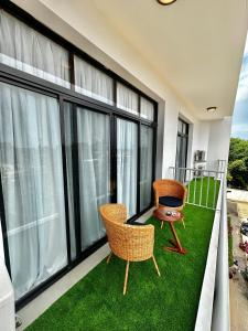 uma varanda com 2 cadeiras e relva verde em Luxury home 75”TV, 5mins from City Center & Beach em Dar es Salaam