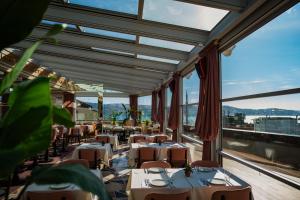 um restaurante com mesas e cadeiras e janelas grandes em Crowne Plaza Istanbul - Ortakoy Bosphorus, an IHG Hotel em Istambul