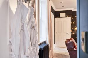 a white robe hanging on a wall in a room at The Snug @ Clarence in Derry Londonderry +35 photos