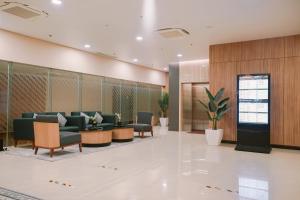 a waiting room with couches and chairs in a lobby at Cordia Hotel Yogyakarta - Hotel Dalam Bandara in Glagah