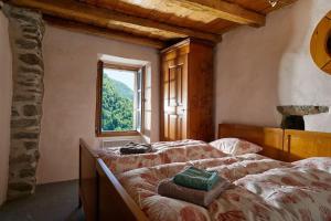 um quarto com uma cama e uma janela em Wild Valley Puro Ticino 1+2 in Valle Onsernone em Crana