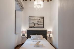um pequeno quarto com uma cama e um lustre em Apartment by The Spanish Steps em Roma