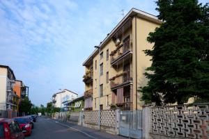 un bâtiment sur le côté d'une rue avec une clôture dans l'établissement Pretty Home Rozzano, à Rozzano