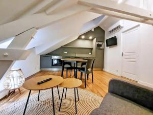 uma sala de estar com um sofá e uma mesa em Appartement Premium dans une belle demeure - Hyper centre-ville de Reims em Reims