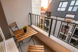 balkon z drewnianą ławką i stołem w obiekcie New Modern & Cozy apartment with FREE Private parking and EV charging station w Warnie
