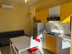 eine kleine Küche mit einem weißen Tisch und einem Herd in der Unterkunft Villa Paeonia in Paestum