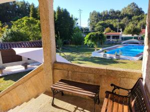 un banco en un balcón con piscina en LA CAMELIA, en Pontevedra