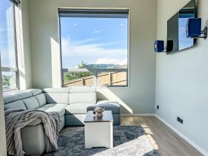 a living room with a couch and a large window at The Lodge @ Pembroke in Wellington