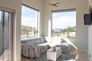 a living room with a couch and large windows at The Lodge @ Pembroke in Wellington