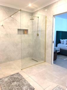 een douche met een glazen deur in een badkamer bij Villa Lamsyh- your second home in Kaapstad