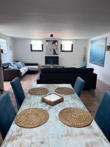 Large Studio Apartment! في كوستا تاغيسي: غرفة معيشة مع طاولة مع كراسي وأريكة
