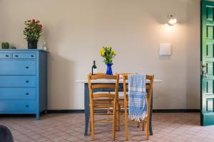 stół jadalny z 2 krzesłami i niebieską komodą w obiekcie Agriturismo San Michele di Danio Giovanni w mieście Dolcedo