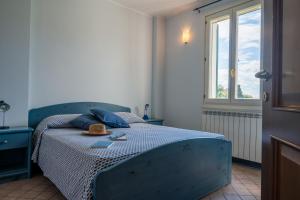una camera da letto con un letto blu e un cappello sopra di Agriturismo San Michele di Danio Giovanni a Dolcedo