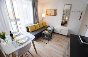 una sala de estar con un sofá y una mesa en Jauki studija su dideliu balkonu Nidos centre, en Nida