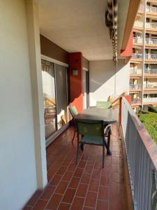 Un balcón con una mesa y sillas en un edificio. en Joli appartement calme avec vue piscine, en Mandelieu-la-Napoule