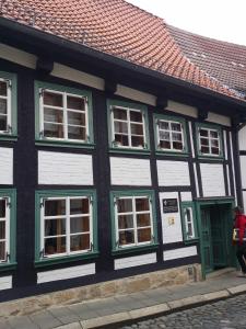 a black and white building with green and white windows at Ferienwohnung im ältesten Fachwerkhaus in Blankenburg