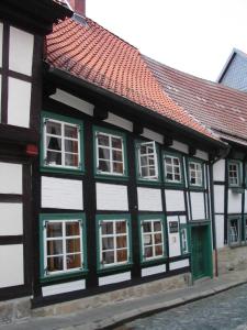 a green and white building with green windows at Ferienwohnung im ältesten Fachwerkhaus in Blankenburg