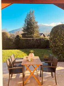 una mesa de patio con sillas y una maceta. en New Villa Montagne & Lac Cheminée 4 chambres vélos, en Saint-Jorioz