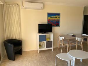 Una sala de estar con una mesa y un televisor. en Joli appartement calme avec vue piscine, en Mandelieu-la-Napoule
