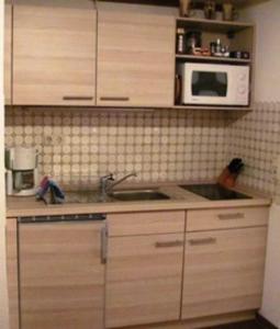 a kitchen with a sink and a microwave at Ferienwohnung im ältesten Fachwerkhaus in Blankenburg