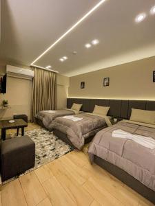 ein Hotelzimmer mit 2 Betten und einem Tisch in der Unterkunft Holy Sheet Plus in Kairo
