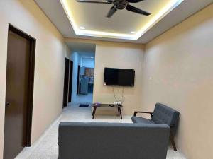 a living room with a ceiling fan and a couch at Homestay Bukit Tinggi Klang in Klang