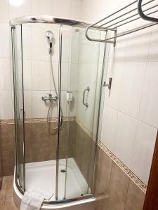 a shower with a glass door in a bathroom at Hotel Logos in Gdańsk