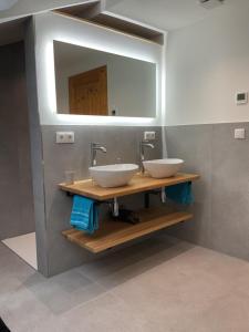 a bathroom with two sinks and a mirror at NEU! FeWo Mansi in Chiemgau in Kienberg