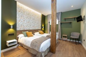 two beds in a room with green walls at Apartamentos LA CAÑADA DE OSMA in El Burgo de Osma