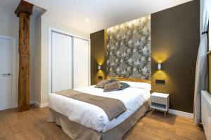 una camera da letto con un letto grande e una grande finestra di Apartamentos LA CAÑADA DE OSMA a El Burgo de Osma