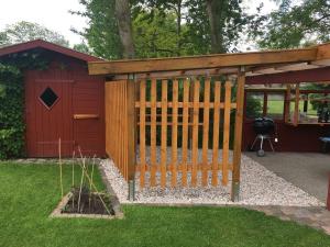 a wooden gate in a garden with a shed at Wohnung-Herzmuschel-im-Haus-Muschelgarten in Alkersum