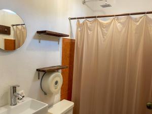 uma casa de banho com uma cortina de chuveiro branca e um WC. em Sac Ek Hotel em Valladolid