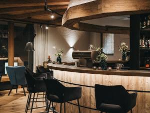 a bar with a row of chairs in a room at VAYA Nauders in Nauders