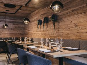 a restaurant with wooden walls and tables and chairs at VAYA Nauders in Nauders