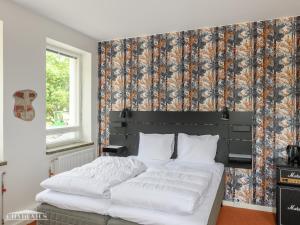 a bedroom with a large white bed with a floral wallpaper at Hangon Asema 1 - lemmikit sallittu in Hanko