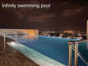 a infinity swimming pool at night on a building at The Podium Studio@Amy*Home in Kuching