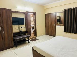 um quarto com uma cama e uma televisão de ecrã plano em Hotel Pearl inn em Rudrapur