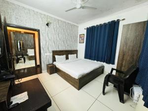 a bedroom with a bed and a mirror and a chair at Hotel Pearl inn in Rudrapur