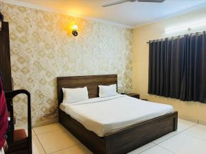 ein Schlafzimmer mit einem Bett in einem Zimmer in der Unterkunft Hotel Pearl inn in Rudrapur