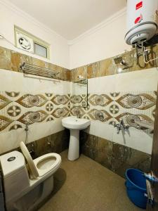 uma casa de banho com um WC e um lavatório em Hotel Pearl inn em Rudrapur