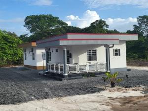 a small white building with a red roof at Augi's Rental in Onverwacht