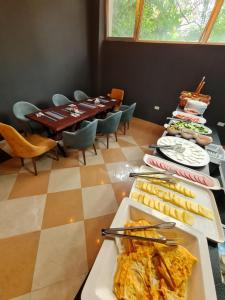 a dining room with a table with plates of food at Hotel Fama in Skopje