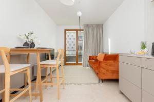 eine Küche und ein Wohnzimmer mit einem Tisch und einem Sofa in der Unterkunft Apartments Arsenal Warsaw City Center by Renters in Warschau