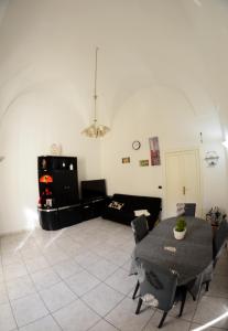sala de estar con mesa y sofá en Origini - Apartment with private Garden en Lecce