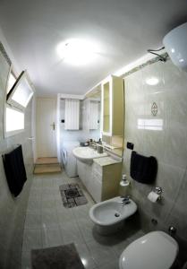 y baño con 2 lavabos, aseo y lavamanos. en Origini - Apartment with private Garden en Lecce