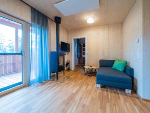 uma sala de estar com um sofá azul e uma grande janela em Seehäuser Dobra 