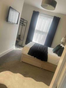 1 dormitorio con cama y ventana grande en Cosy modern one bedroom flat en Hartlepool